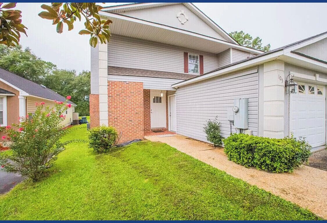 A two-story house with a brick section and a garage.