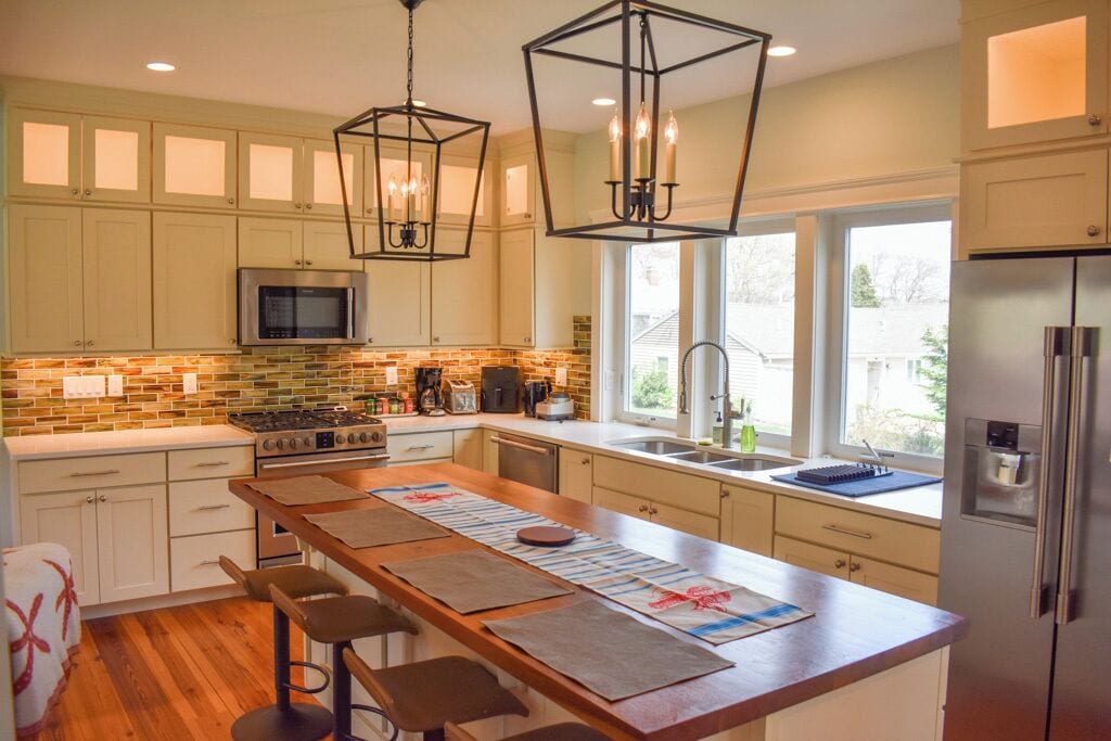 A modern kitchen with a central island, stainless steel appliances, and pendant lighting.