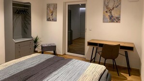 Une chambre à coucher avec un lit, un bureau et deux tableaux.