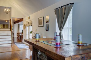 A wooden dining table with a board game, a can of drink, and a disco ball.