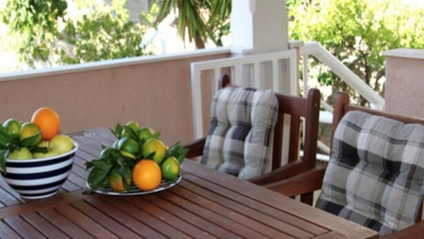 Une table en bois avec un saladier rempli de fruits et une assiette de fruits.