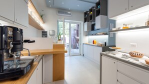 Una cocina moderna con cafetera, mostrador de madera y vistas al exterior.