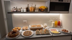Un bufé de desayuno con diversos pasteles, pan, huevos y salsas.