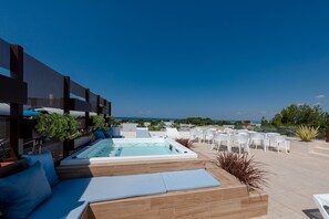 A rooftop terrace with a hot tub, lounge chairs, and outdoor seating. - Dolcirive B&B (Porto Cesareo)