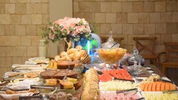 A buffet table with various food items and a vase of flowers.