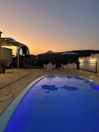 Una piscina al aire libre, sombrillas, sillones reclinables de piscina. Pousada Maria Monteiro