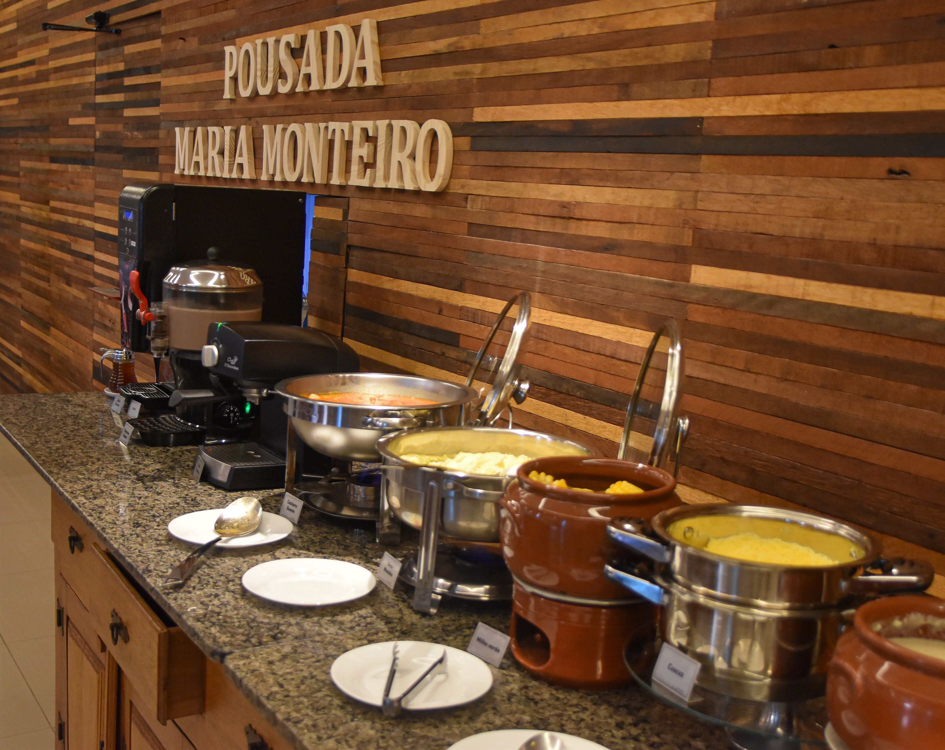 A buffet area with various food containers and a coffee machine.