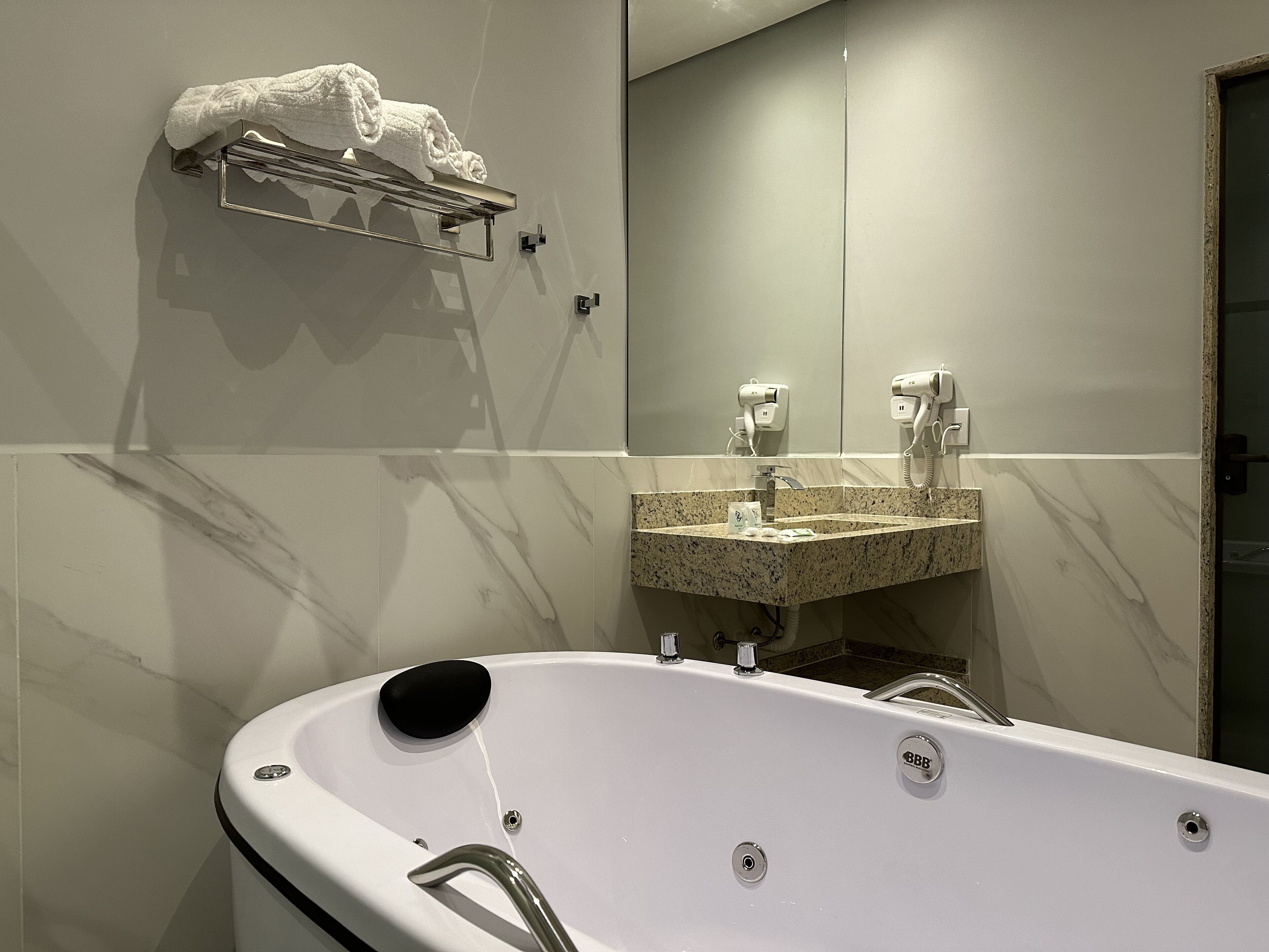 A modern bathroom with a freestanding bathtub, a vanity with a marble countertop, and a towel rack.