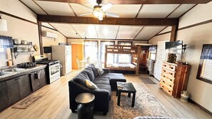 A compact living space with a kitchen, a sofa, a dining area, and a sleeping area. - Spring River Fishing Cabins #1 - Maple - Dogs ok (Miami)