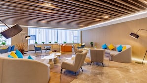 Zona lounge moderna con divani, poltrone e tavolino.