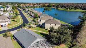 A residential area with houses, a swimming pool, and a lake.