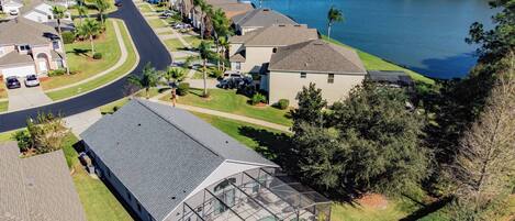 A residential area with houses, a swimming pool, and a lake.