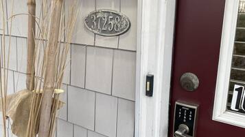 A house number 37258 on a light grey siding wall, a red door with a window, and a mailbox.