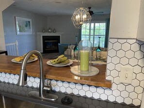 Een keuken met een modern design, voorzien van een backsplash met hexagontegels, een houten aanrecht en een roestvrijstalen spoelbak.