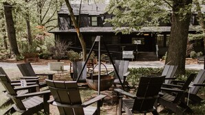 Un espace extérieur aménagé avec des chaises Adirondack et un foyer.