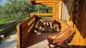 A wooden deck with a picnic table and two lounge chairs. - Chalet 6 Agriturismo (Tocco da Casauria)