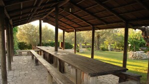 An outdoor covered picnic area with stone flooring and wooden benches. - Dante Pino in Tocco da Casauria (Tocco da Casauria)
