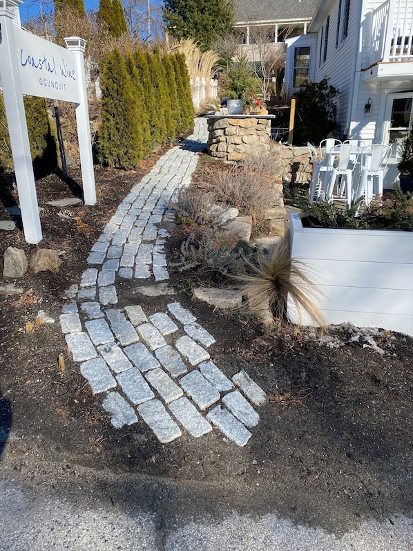 A stone pathway leading to a building with a sign reading "Coastal Wine Ogunquit." - Renovated 2 bedrm apt located in heart of Ogunquit (Ogunquit)