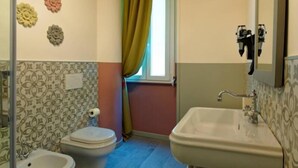 Une salle de bain équipée de toilettes, d’un bidet et d’un lavabo.