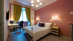 Une chambre à coucher comprenant un lit, des tables de chevet, un bureau avec une chaise, un lustre et des rideaux.