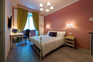 Classic hotel room with a single bed, bedside table, and comfortable chair.