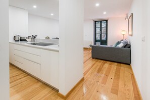 Cozy living space with a kitchenette, sofa, and window offering a view of the outdoors.