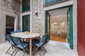 Enjoy al fresco dining in a charming outdoor space with a round table and comfortable seating for four.