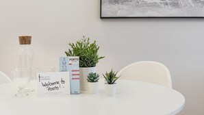 Ein Tisch mit einem Willkommensschild, einer Stadtkarte, einer Glasflasche und Topfpflanzen.