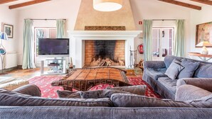 Una sala de estar acogedora con chimenea, televisor y sofá.