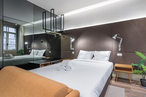 Relax in a stylish room with a large bed, bedside table, and potted plant.