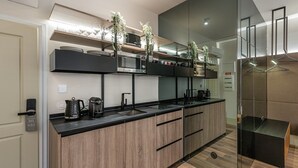 Une cuisine moderne avec un plan de travail noir, des armoires en bois et un four à micro-ondes encastré.