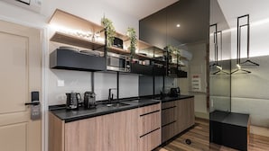 Une cuisine moderne dotée d’un plan de travail en bois, d’appareils électroménagers intégrés et d’une cloison en verre.
