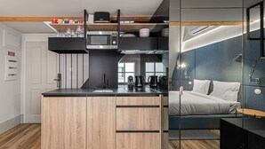 A modern kitchen with a wooden island, a microwave, and a coffee maker. - GuestReady - Mercadores Apartments - Room G (Porto)