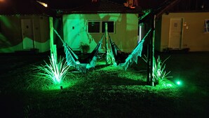 A house with a hammock in the front yard, a door, and a window. - Águas Chalés Temporada (São Pedro)