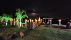 A well-lit outdoor area with a pool, seating areas, and a gazebo. - Águas Chalés Temporada (São Pedro)