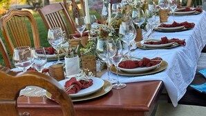 An outdoor dining table set with chairs, glassware, and a decorative rooster statue in the background. - FarmStay HillTop wine country views 6BR/4BA (Paso Robles)