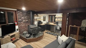 Un salon confortable avec une cheminée, un téléviseur et un canapé.