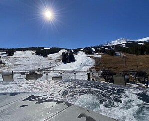 Schneeverdeckte Landschaft mit blauem Himmel und strahlender Sonne.
