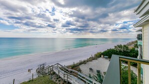 A beach view from a balcony with a wooden deck, a sandy beach, and a clear sky. - 30A Gulf front 2 Bed/2 Bath Sleeps 6 Private beach- Beach service included (Santa Rosa Beach)