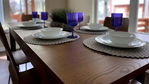 A dining table set with white bowls and blue glassware on a wooden table with a lace placemat. - Cozy Home near Alamodome~Free Gated Parking~Kids Climbing Dome & Backyard games (San Antonio)