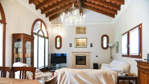 Una habitación amplia con chimenea, televisor y comedor.