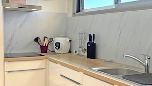 Eine moderne Küche mit Backofen, digitaler Küchenwaage und Messerblock.