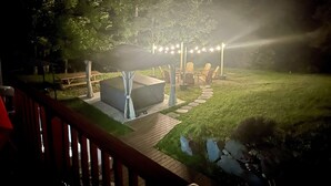 Una terraza con mobiliario exterior, un espacio cubierto y un camino de piedra.