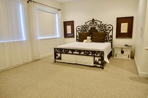 Relax in a serene space with a comfortable bed, bedside table, and large window.