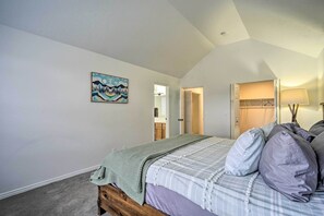 Quarto com cama, quadro, armário e abajur.
