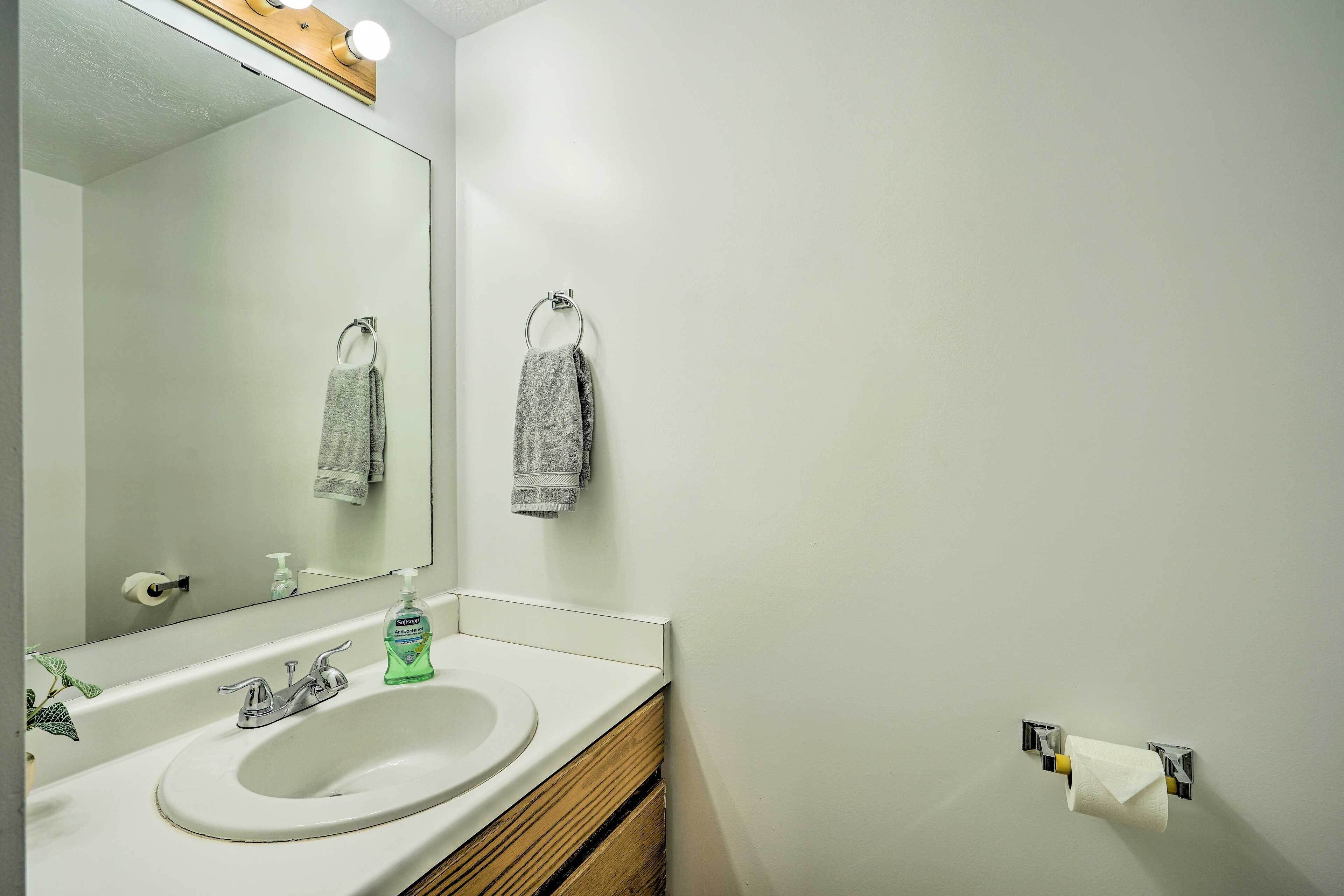 Une salle de bain avec un lavabo blanc, un miroir et un porte-serviettes.