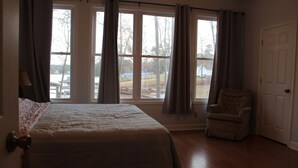 A bedroom with a bed, a chair, and a door. - Beautiful quiet home in cove with dock (Greenwood)