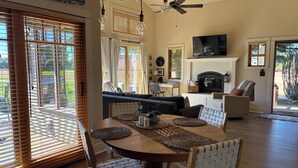 Un espace repas comprenant une table ronde, des chaises et un ventilateur de plafond.