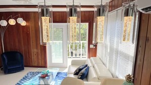 A modern kitchen with a central island, pendant lights, and a view to the outside. - New* Nature view #2/ 1 BED pool, walk to beach (Fort Myers Beach)