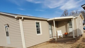 A two-story house with a front porch, a small attached garage, and a white picket fence. - Make this house your HOME away from home (Meade)